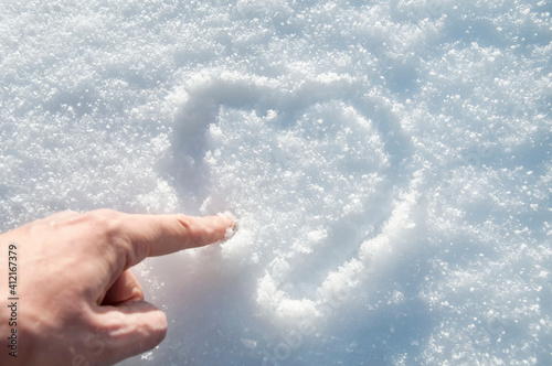 he draws a heart on the snow with his finger