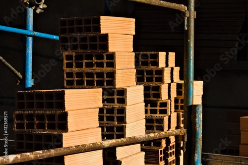 Hollow construction bricks stacked on a construction site on the scaffoldings (Pesaro, Italy, Europe)