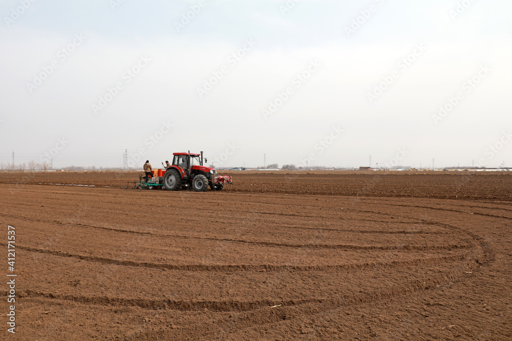 Farmers drive planters to grow potatoes on the farm. Farmers drive planters to grow potatoes on the farm.