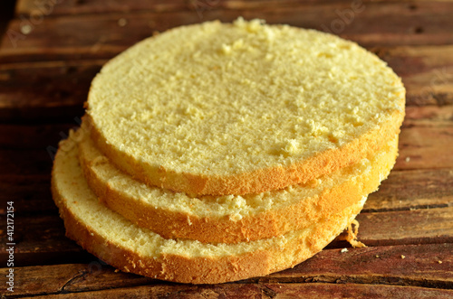 Fototapeta Gluten-free sponge cake cut into rings on a wooden background