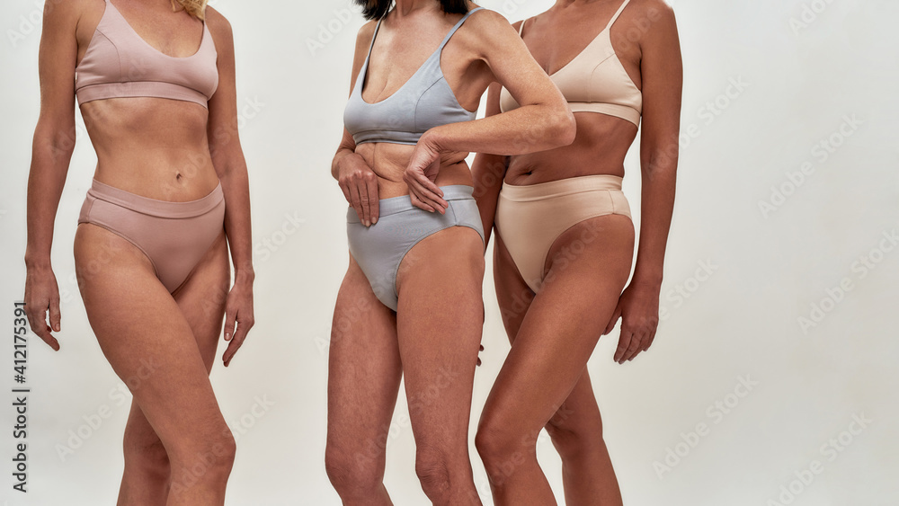 Loving my aging body. Cropped shot of three senior women in underwear  posing half naked in studio against light background foto de Stock