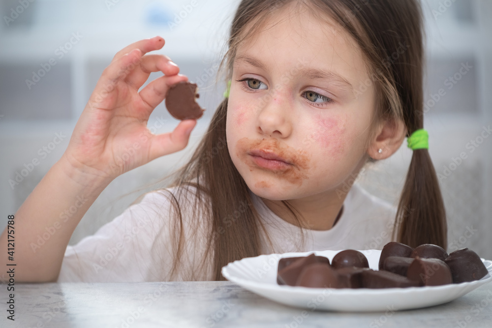 Stockfoto A little girl with an allergic rash on her cheeks sits at a