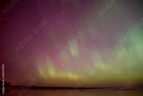 Intense northern lights (Aurora borealis) over Baltic sea. rocky beach photo