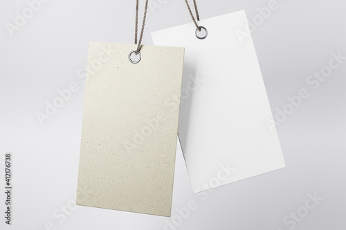 Blank grey hanging tag made from recycled eco-friendly paper with cotton twine at light abstract background. Mock up. Eco label tag concept. 3D rendering
