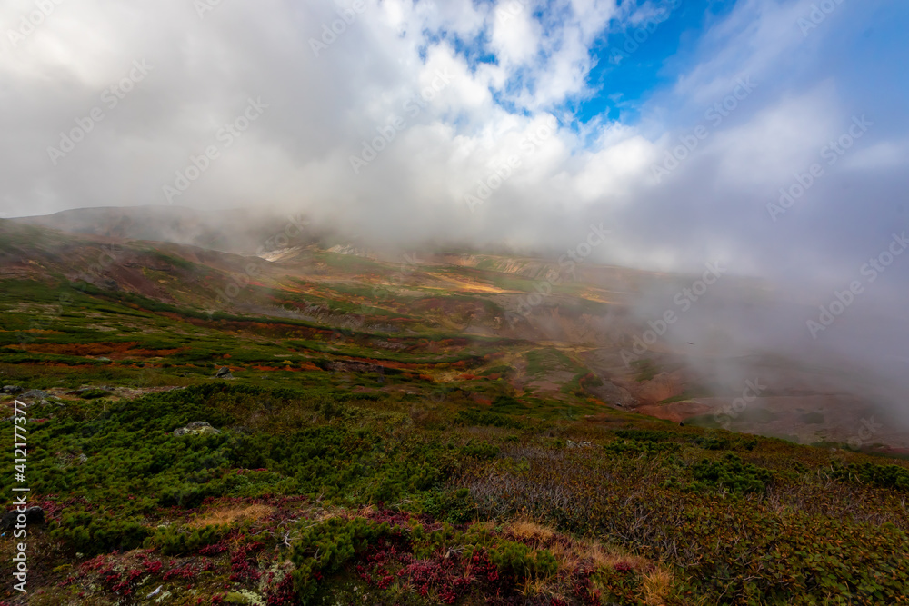 秋の北海道・大雪山で見た、雲に覆われる北海岳山頂付近の紅葉と雲間から見える青空