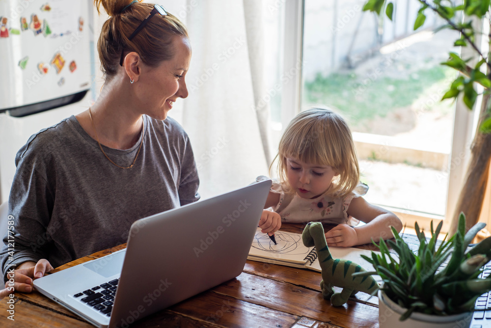business woman is working at home on a computer with her baby business woman is working at home on a computer with her baby