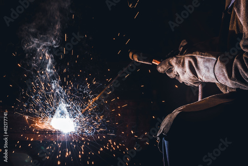 Industrial welder welding fabricated construction in factory, Welding process by Shielded Metal Arc Welding (SMAW) or Stick Welding. photo