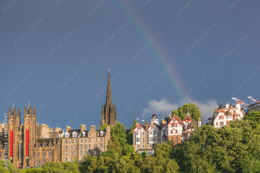 Obraz premium Rainbow over Ramsay Garden, Tollbooth Kirk and the old town skyline on a moody and colourful summer evening in Edinburgh, Scotland