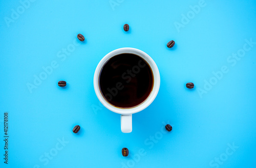 Black coffee cup on blue background with Coffee beans arrang as forming clock face