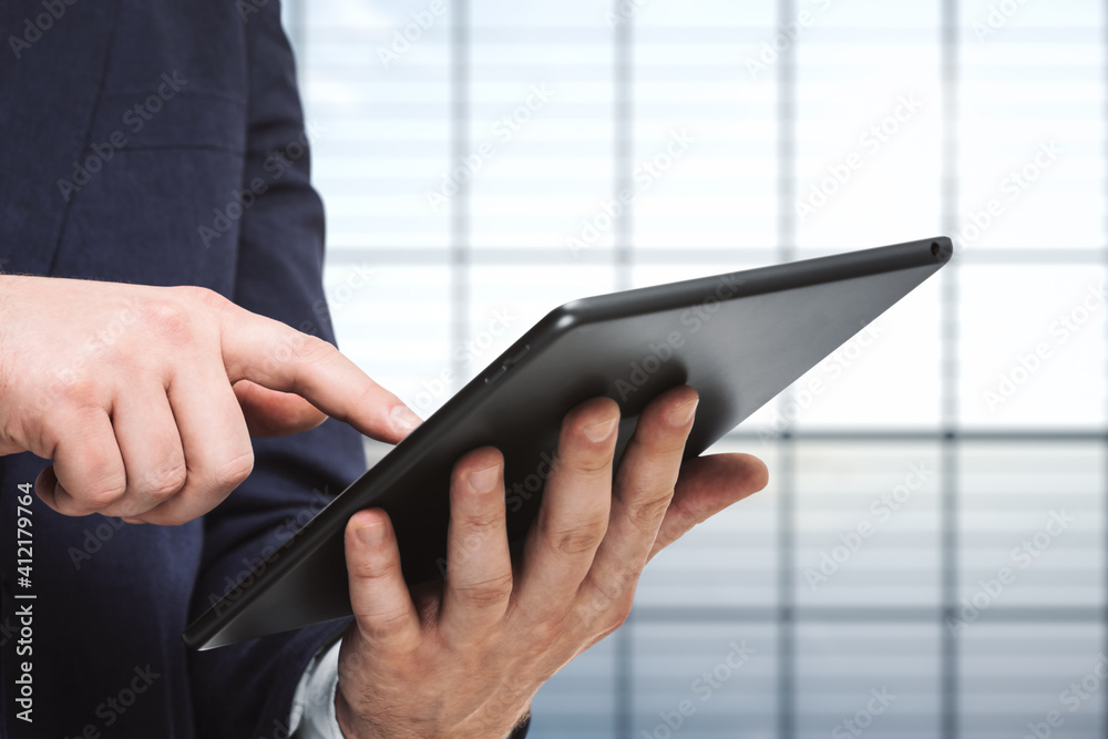 Businessman holds digital tablet and clicks on screen in modern office, close up. Search concept Businessman holds digital tablet and clicks on screen in modern office, close up. Search concept