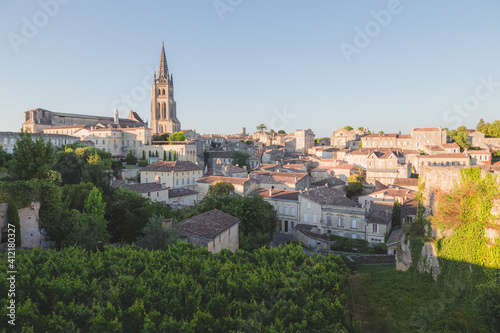 A vineyard view of the Monolithic Church and village of Saint-Emilion in Bordeaux wine country on a sunny summer day.
