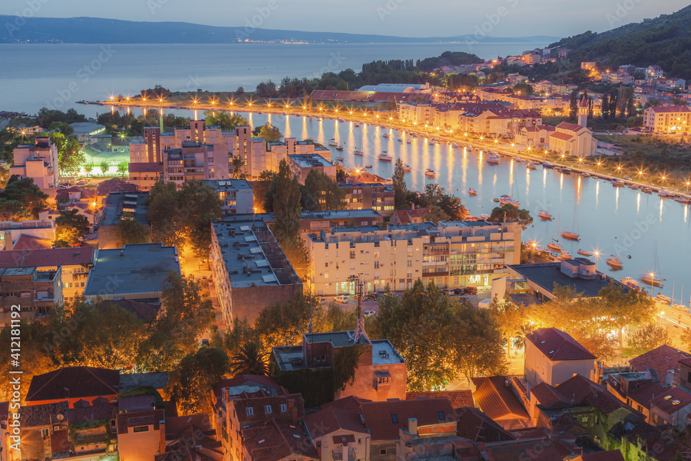 Cityscape view at night over old town Omis and the Cetina River on the Adriatic coast in the Split Dalmatia region of Croatia