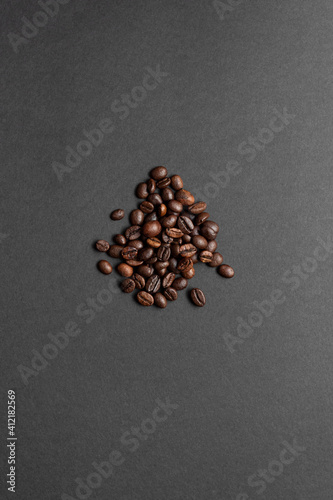 Bunch of roasted coffee beans spread over a dark background