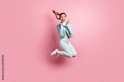 Full length photo portrait of amazed woman jumping up isolated on pastel pink colored background