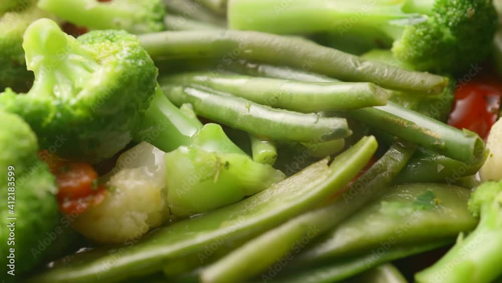 Broccoli, string beans and cauliflower are fried in oil in a frying pan Broccoli, string beans and cauliflower are fried in oil in a frying pan
