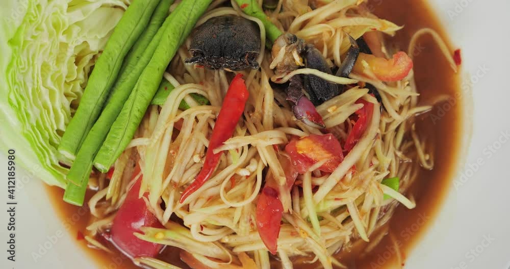 Papaya salad or som tam spicy with crab and pickled Fish on white background. Popular Thai food.