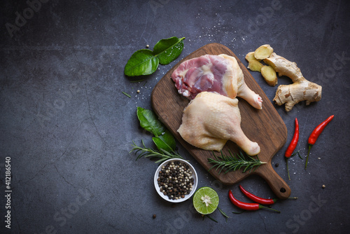 Raw duck legs with herb spices ready to cook on wooden cutting board, Fresh duck meat for food