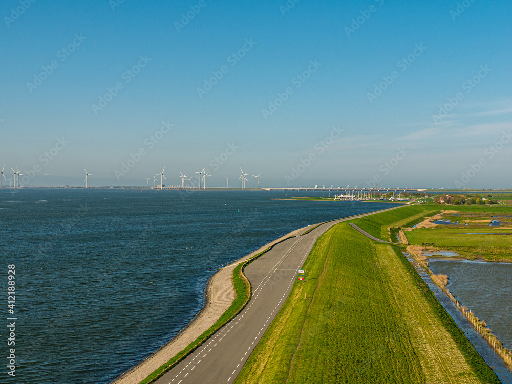 Sea dike with wind turbines and a marina in Zeeland, the Netherlands