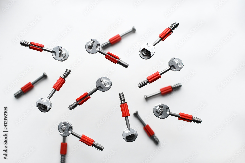 Minifix bolt set, with plastic shaft, eccentric. Background from screws and dowels. Collection of metal bolts on a white background. Levitation of objects on white background Minifix bolt set, with plastic shaft, eccentric. Background from screws and dowels. Collection of metal bolts on a white background. Levitation of objects on white background