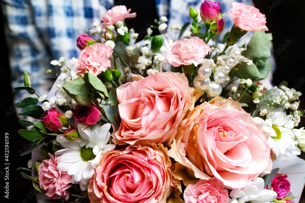 Extremely close-up. Man gives flowers. Gift box with flowers. Close up of box with pink roses in male hands. Male give gift for mother's day, valentines, women day, birthday. Selective focus