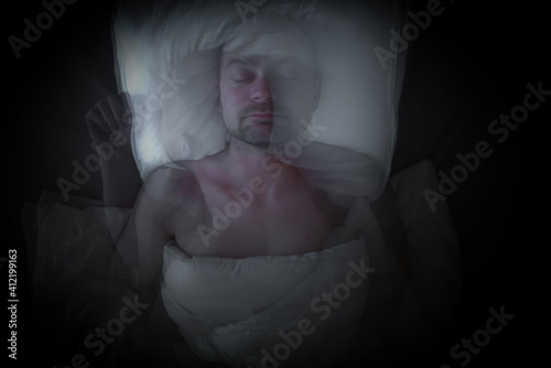 Man having bad dreams and moves his head. Time lapse photo with abstract motion blur.