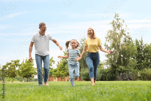Happy family running in park on summer day