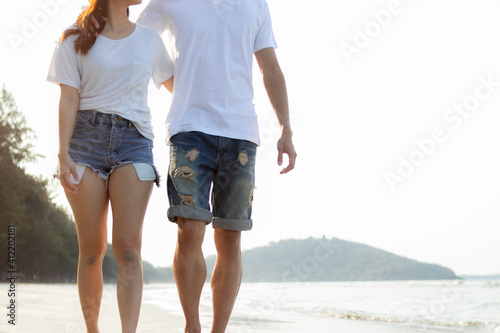 Close up couple walking on beach together. Romantic beach vacation.