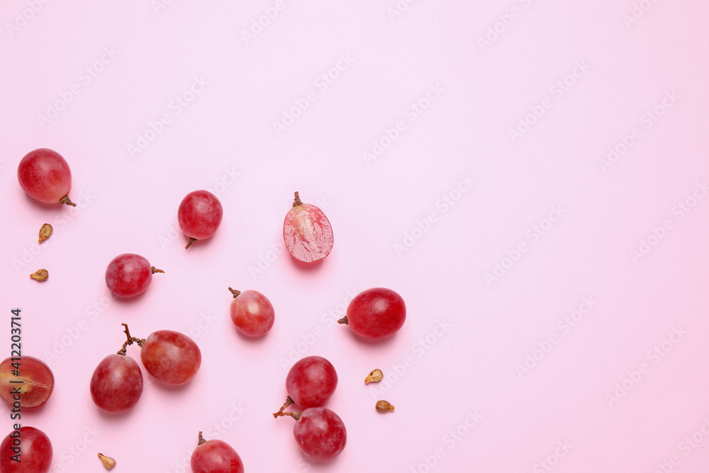 Flat lay composition with fresh ripe grapes and seeds on pink background. Space for text Flat lay composition with fresh ripe grapes and seeds on pink background. Space for text