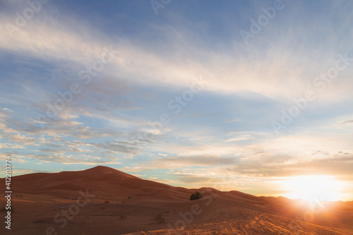 A sunrise or sunset landscape view of the desert sand dunes of Erg Chebbi near the village of Merzouga, Morocco.