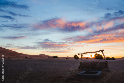 A colourful sunrise or sunset over a water well outside the village of Merzouga, the gateway to the Erg Chebbi desert dunes in Morocco. © Stephen