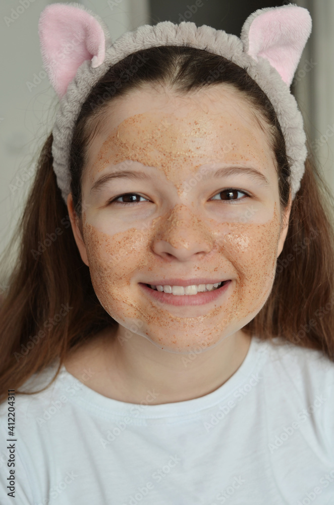 Portrait of a beautiful girl with a cosmetic mask on her face. She has brown eyes and white teeth. Portrait of a beautiful girl with a cosmetic mask on her face. She has brown eyes and white teeth.