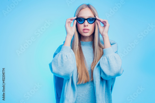 Fashion shot of young model wearing blue sunglasses and clothes