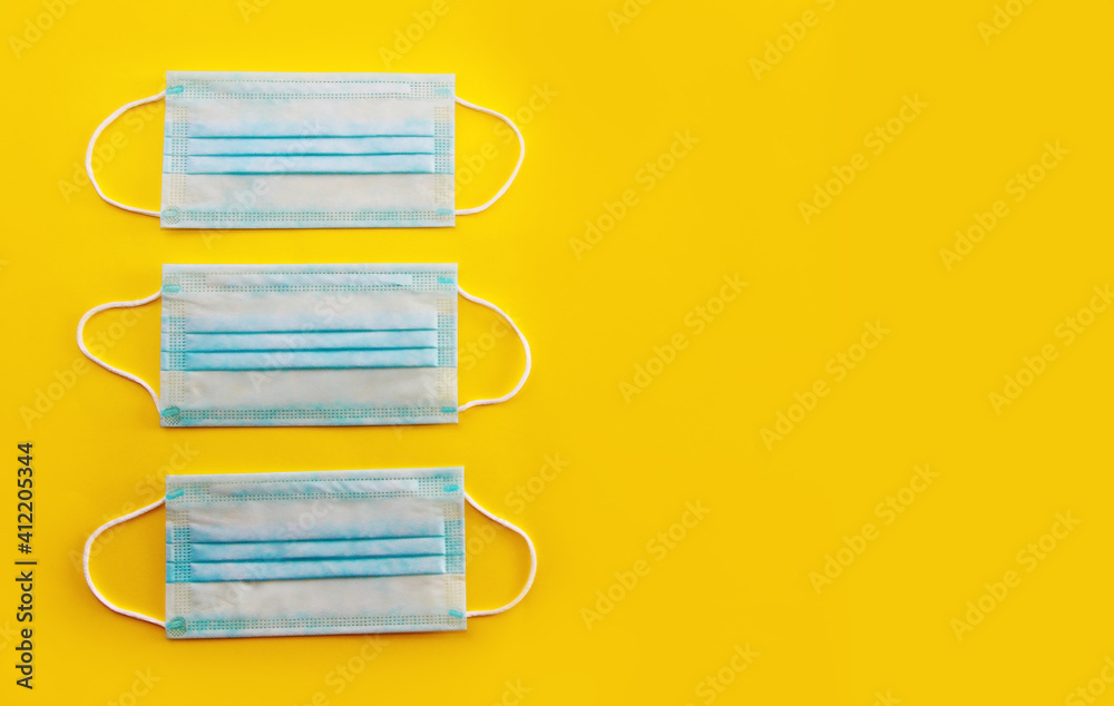 blue medical masks on a yellow background blue medical masks on a yellow background