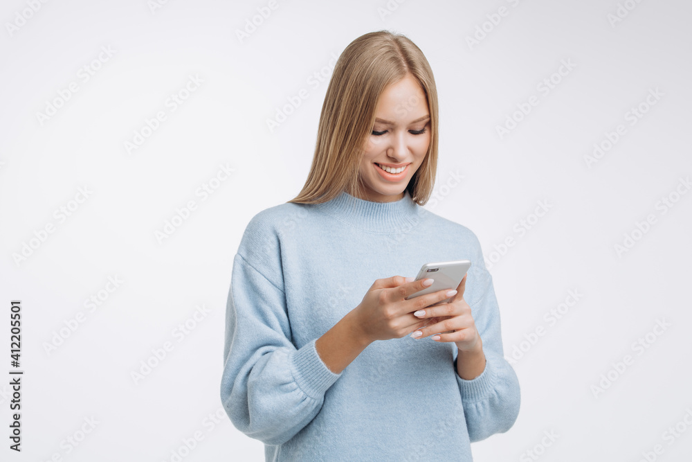 Fototapeta premium Beautiful girl reading a message or watching something on her phone