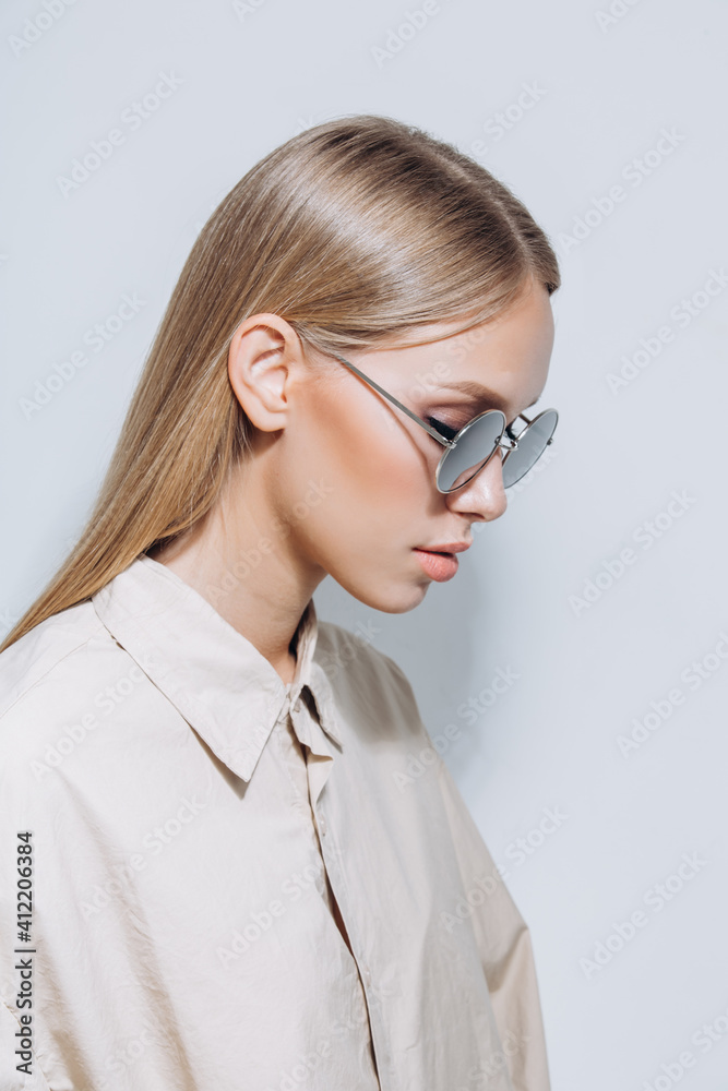 Simple shot of stylish perfect skin model in sunglasses and shirt