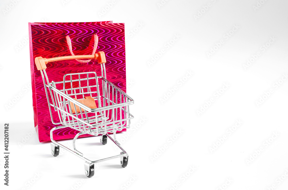 the concept of online Commerce shopping cart and package in red on white background with place for text the concept of online Commerce shopping cart and package in red on white background with place for text