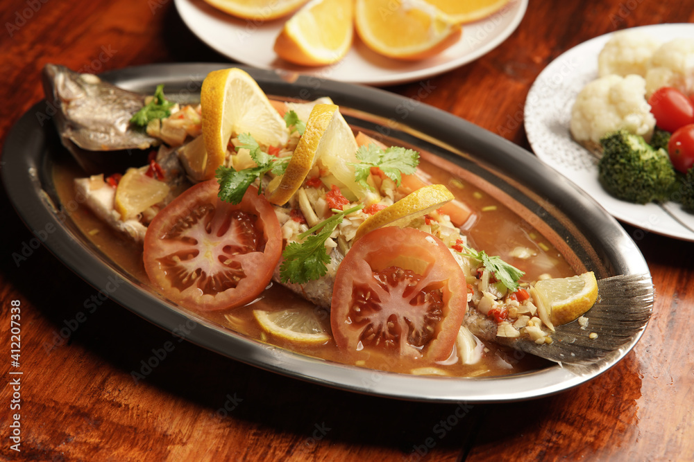 siakap steam delicious Malaysian dish on wood background siakap steam delicious Malaysian dish on wood background