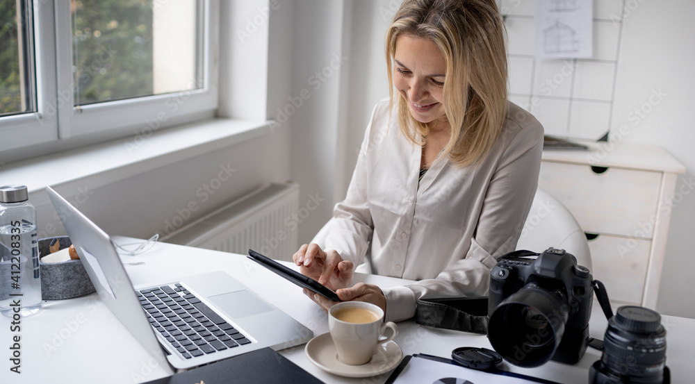 Portrait of photographer woman working home office holding camera with laptop. Portrait of photographer woman working home office holding camera with laptop.
