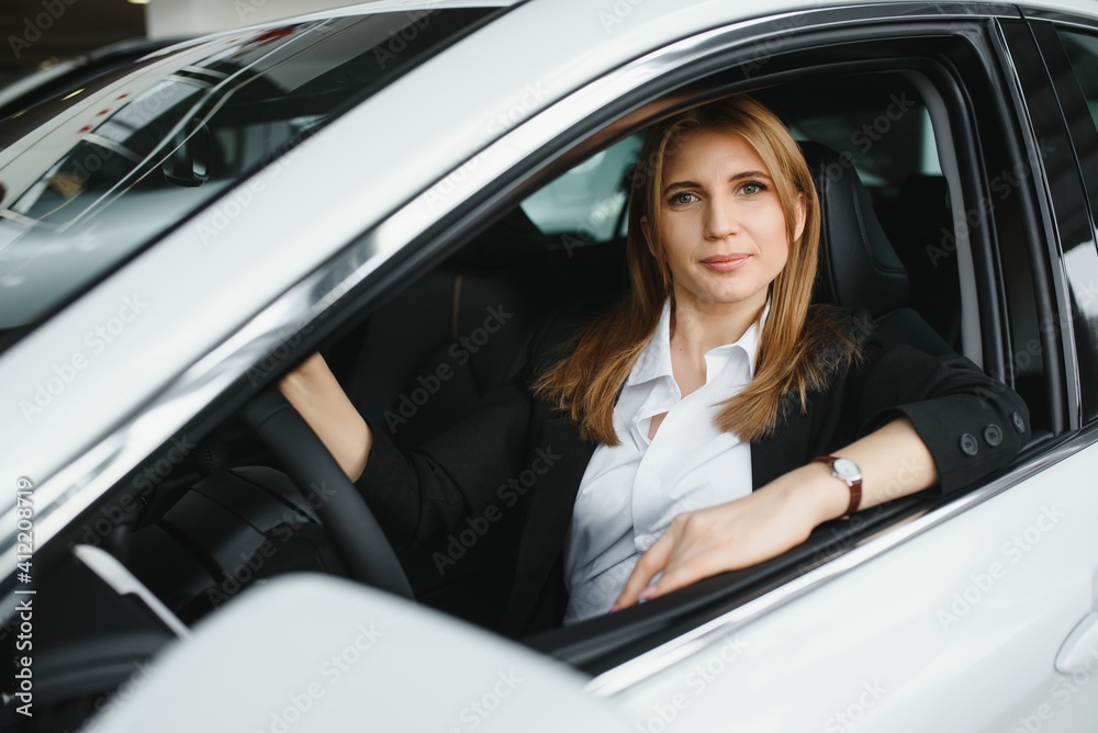 young beautiful business woman sitting in her car