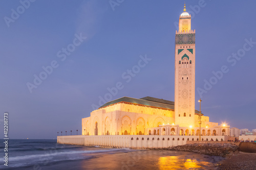 The grand and iconic Hassan II Mosque illuminated at night in Casablanca, Morocco.