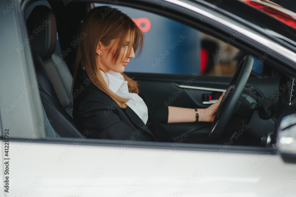 Photo of happy young woman sitting inside her new car. Concept for car rental