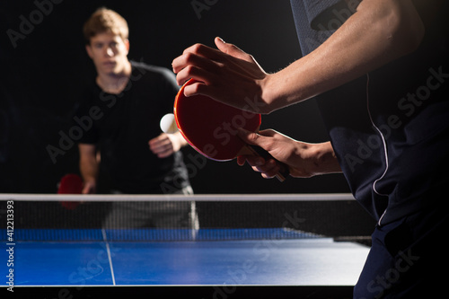 Table tennis ping pong paddles and white ball on blue board photo
