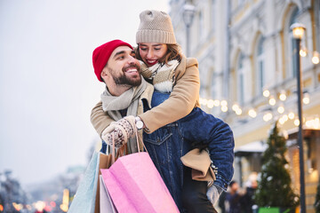 Happy young couple going shopping in winter