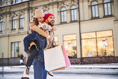 Merry young couple going shopping on winter day photo