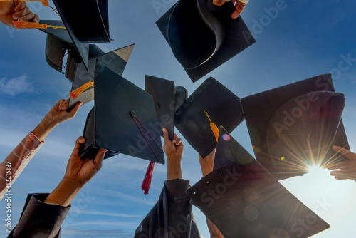 Photo Graduates throwing graduation hats Up in the sky