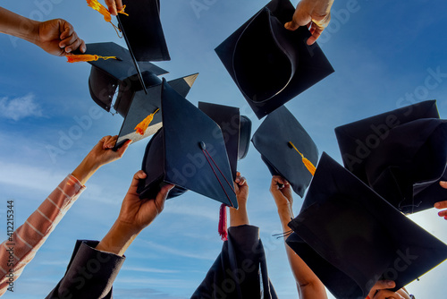 Graduates throwing graduation hats Up in the sky