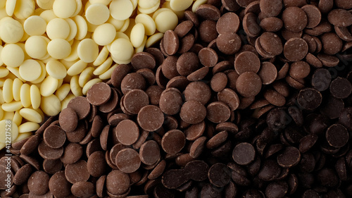 chocolate chips from white, milk, black chocolate top view. confectionery concept