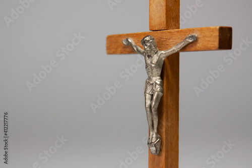 Horizontal close-up conceptual photography of a crucifix with a silver figurine Fototapet