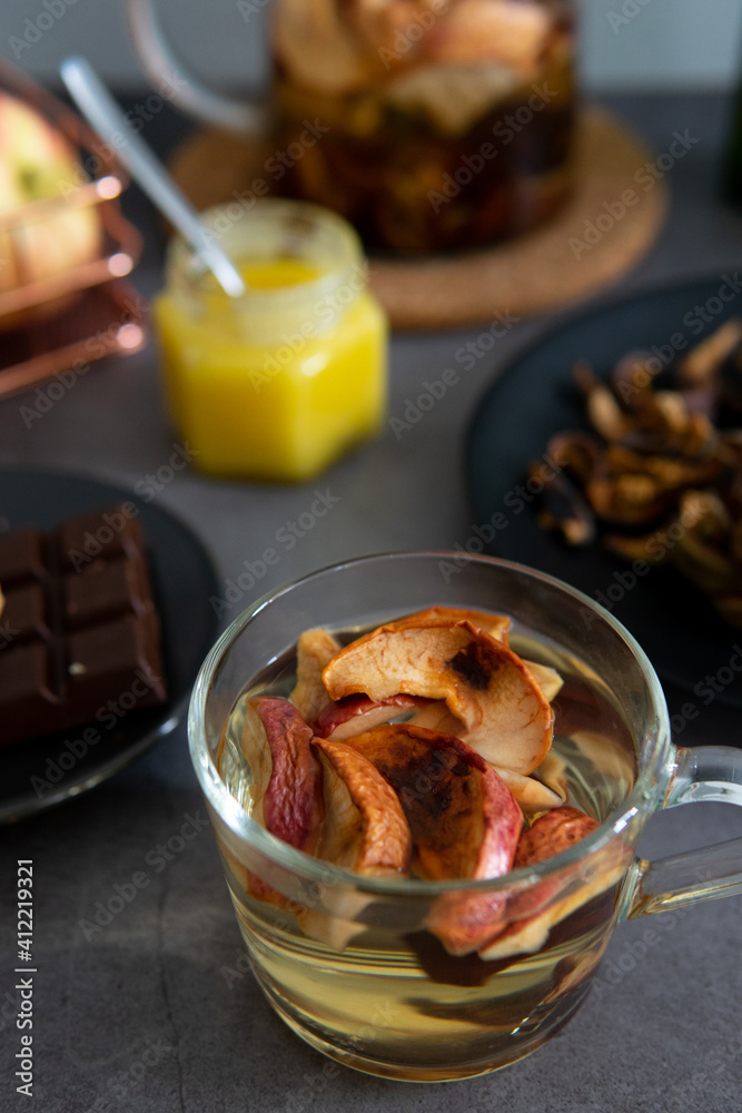 Composition of tea drinking. On a dark background, tea with dried fruits, apples, honey and chocolate. Antiviral kit. View from above Composition of tea drinking. On a dark background, tea with dried fruits, apples, honey and chocolate. Antiviral kit. View from above