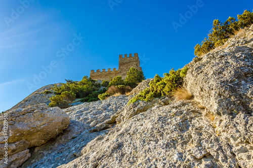 A fortress with towers on top of a cliff.